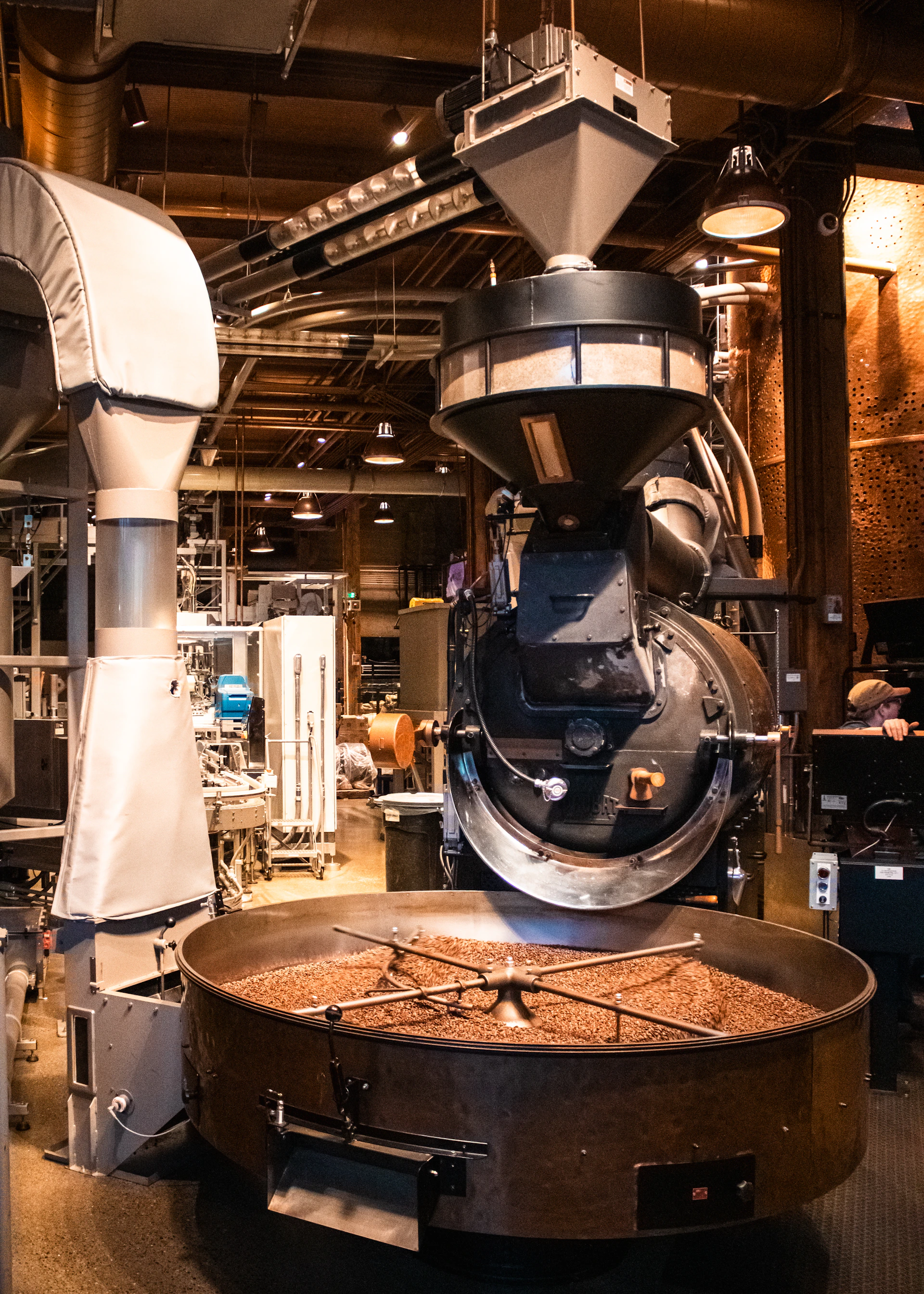 Coffee beans are being roasted in a large machine.