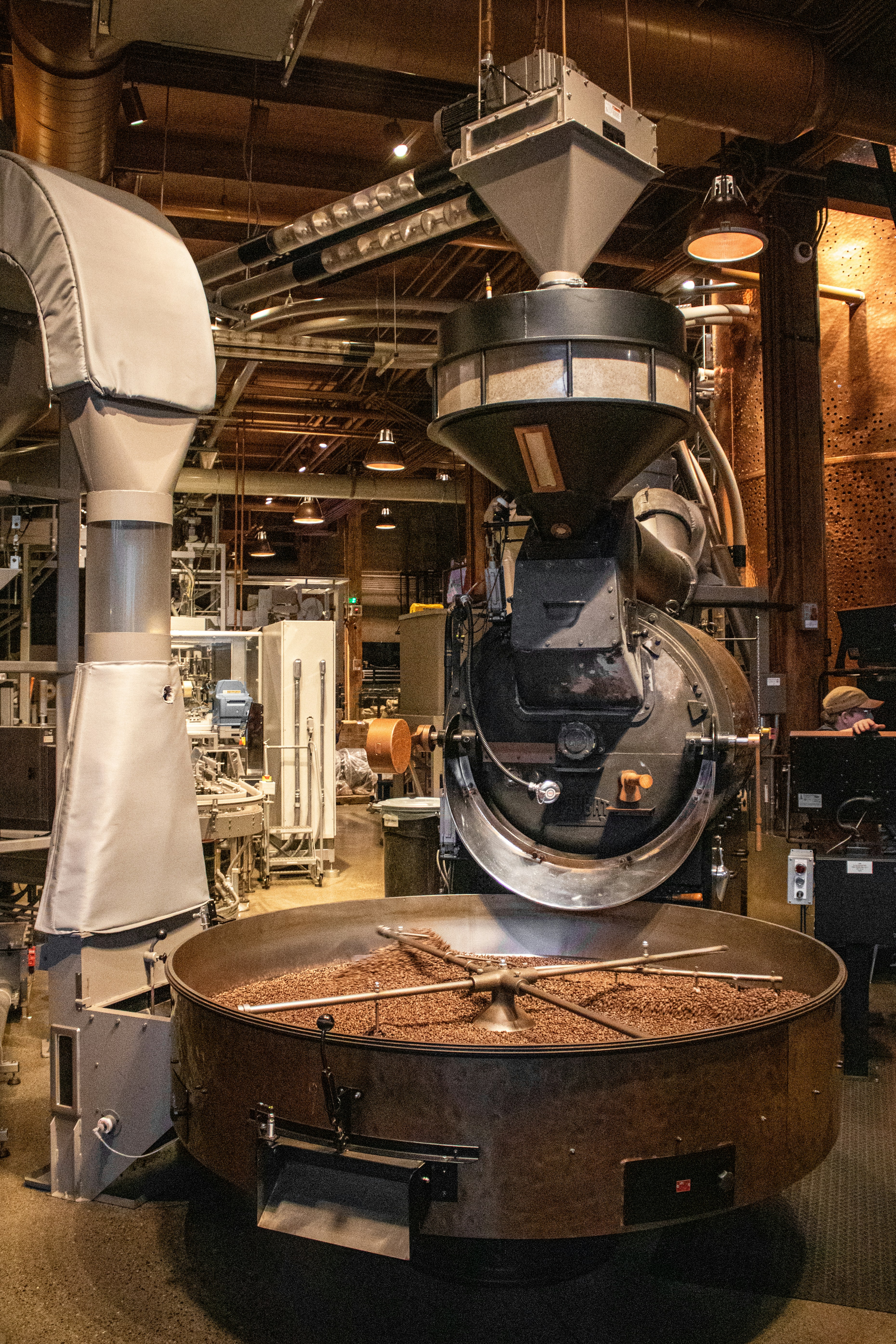 Coffee beans are being roasted in industrial equipment.