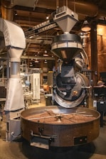 Coffee beans are being roasted in industrial equipment.
