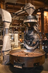 Coffee beans are being roasted in industrial equipment.
