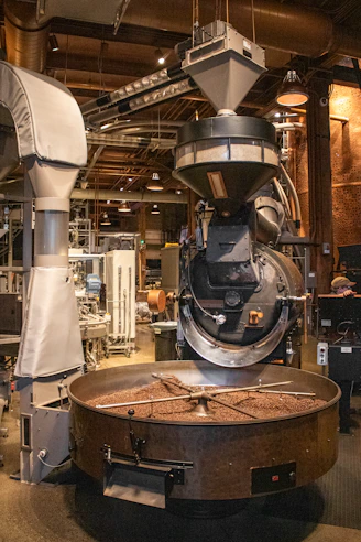 Coffee beans are being roasted in industrial equipment.