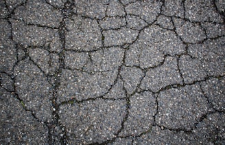 Cracked asphalt shows signs of wear and tear.