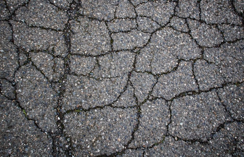 Cracked asphalt shows signs of wear and tear.
