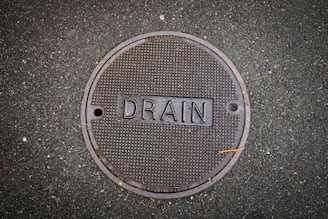 Drain cover with the word "drain" on it.