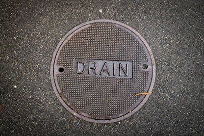 Drain cover with the word "drain" on it.
