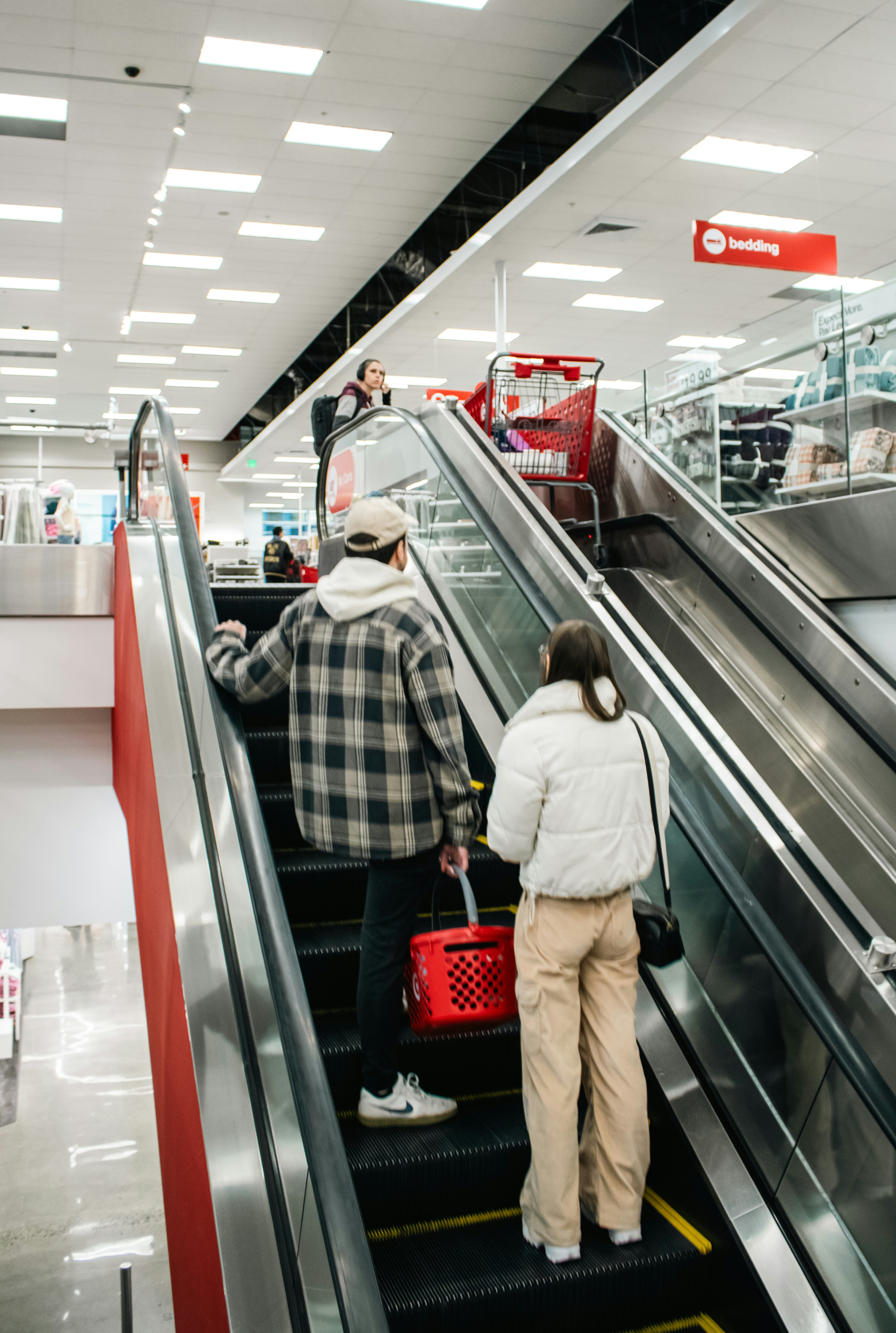 People ride an escalator inside a target store.