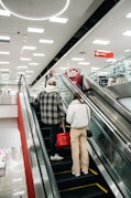People ride the escalator in a retail store.