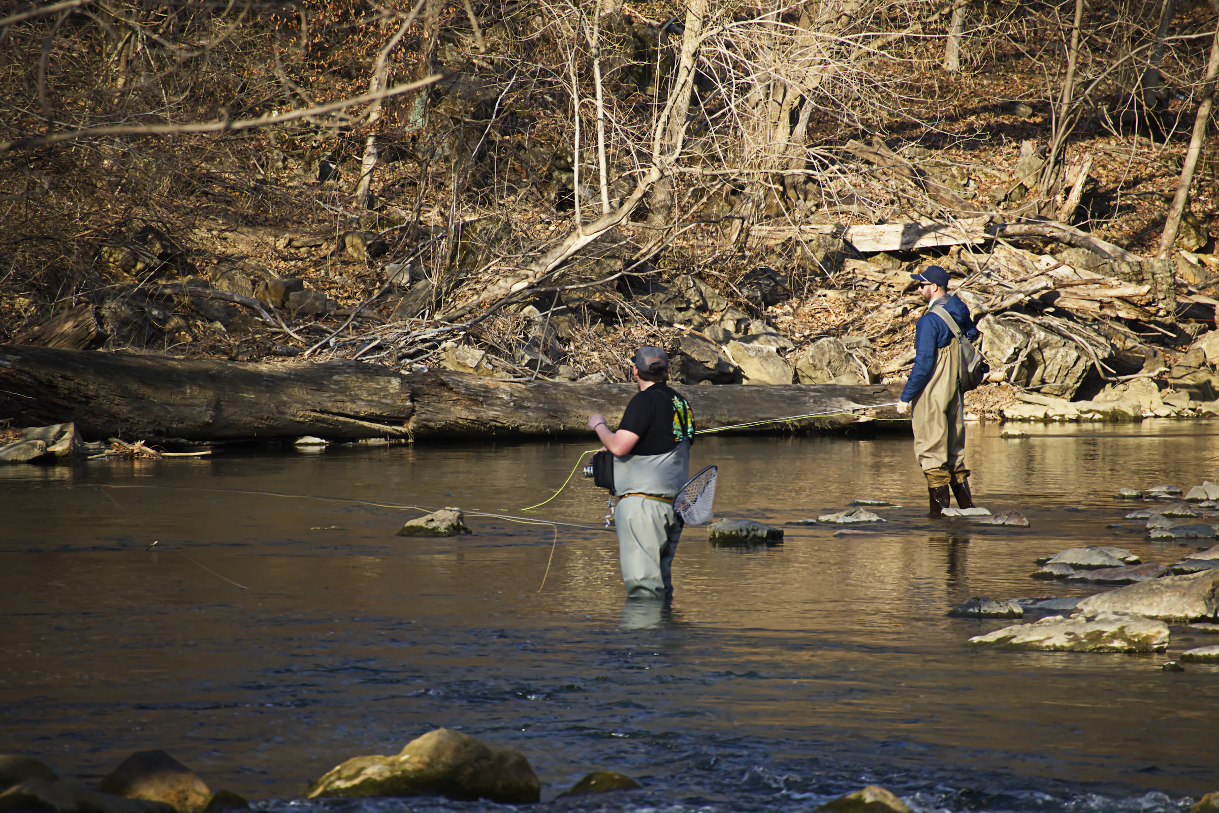 A guide and angler fly fishing a river together
