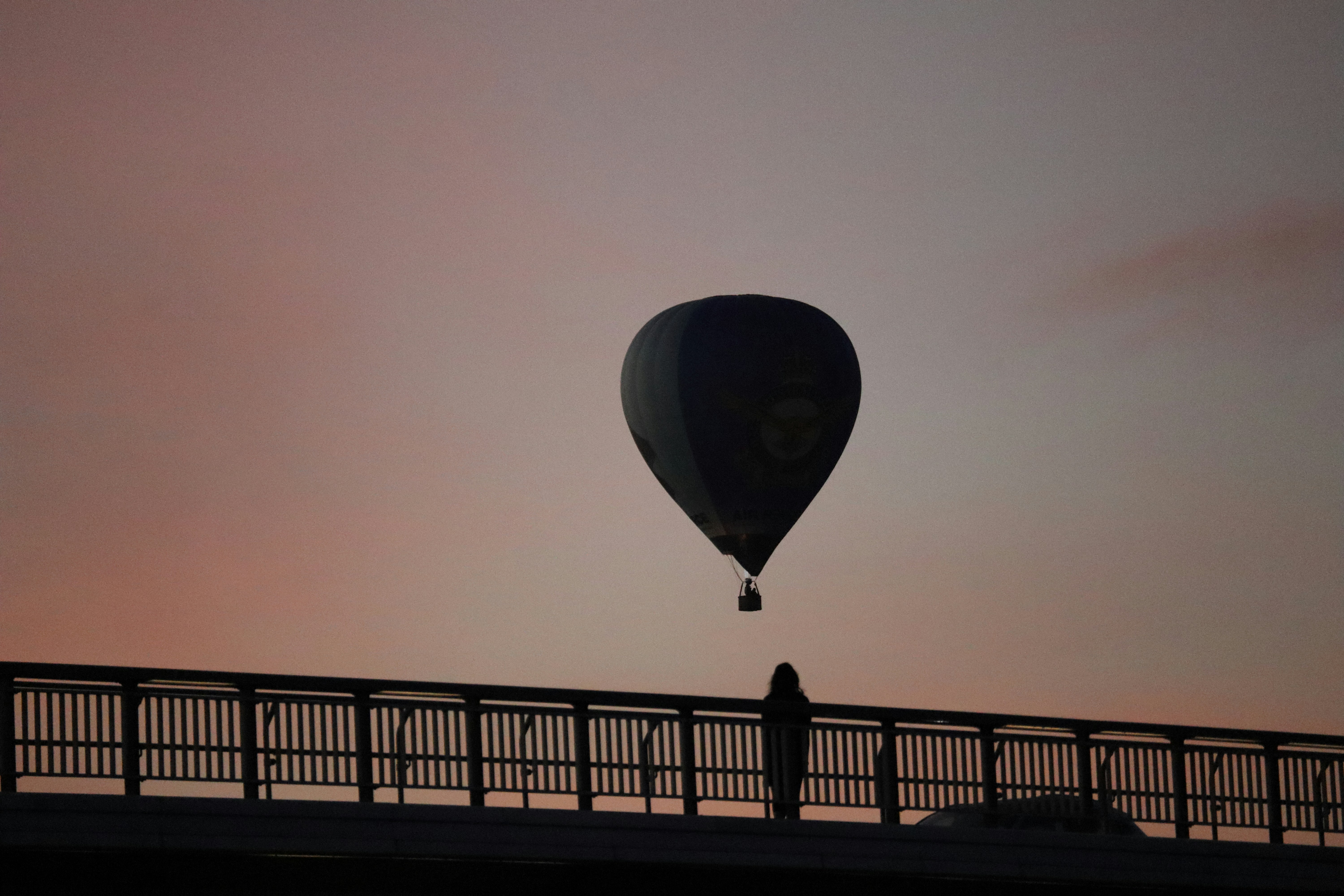 A hot air balloon floats in a colorful sunset sky.