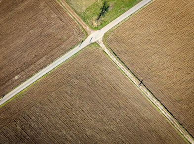 Roads cross through tilled farm fields.