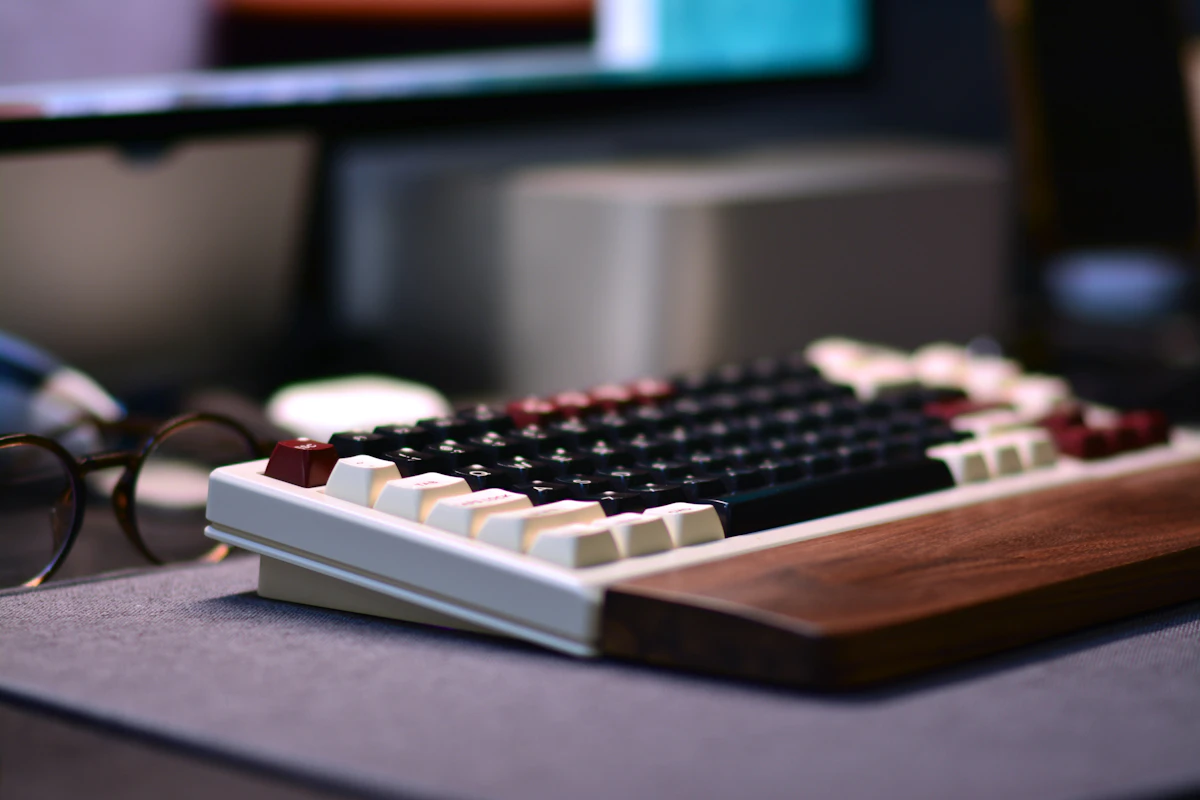 A mechanical keyboard with a wooden wrist rest.
