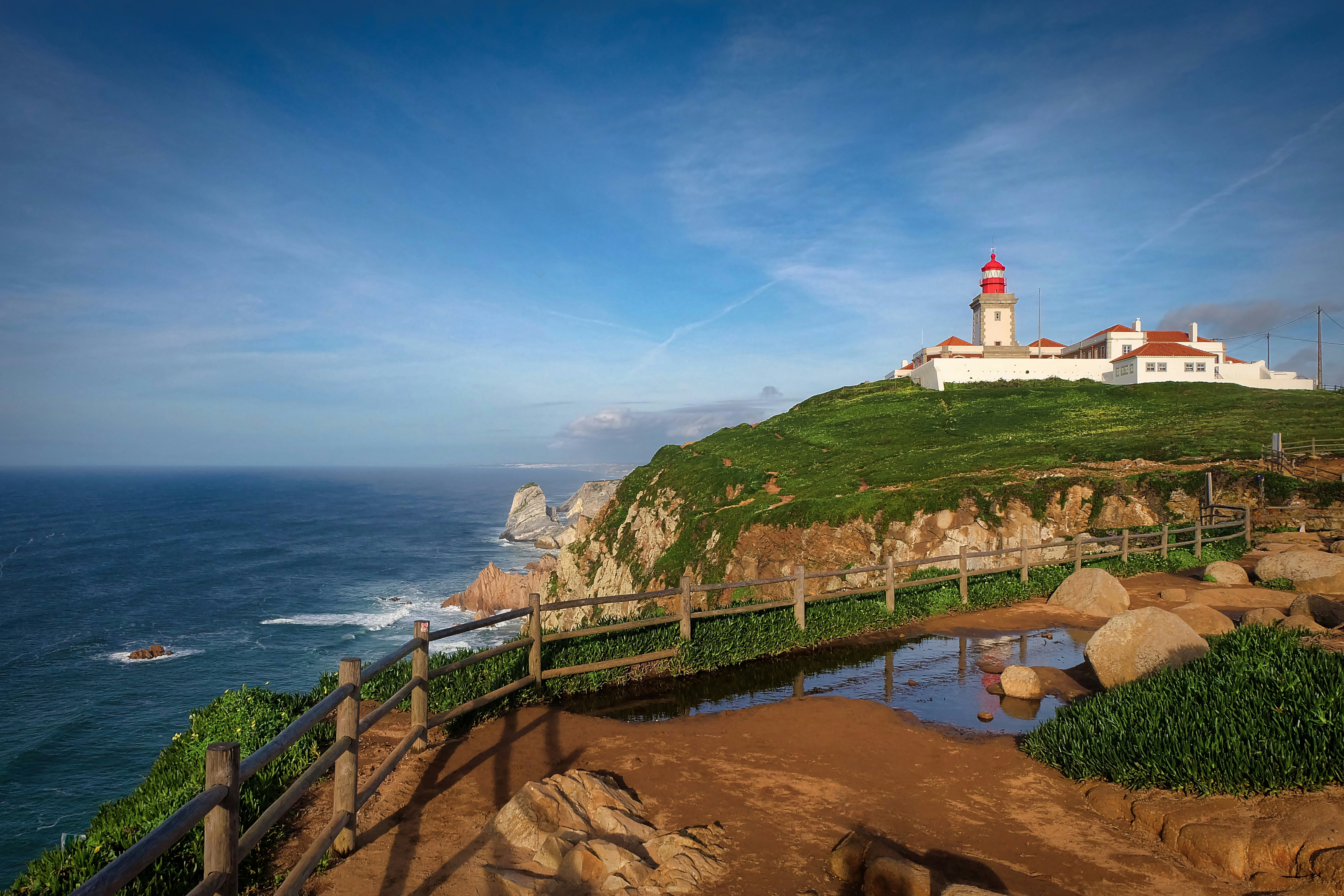 Il faro si trova su una scogliera in riva all'oceano.
