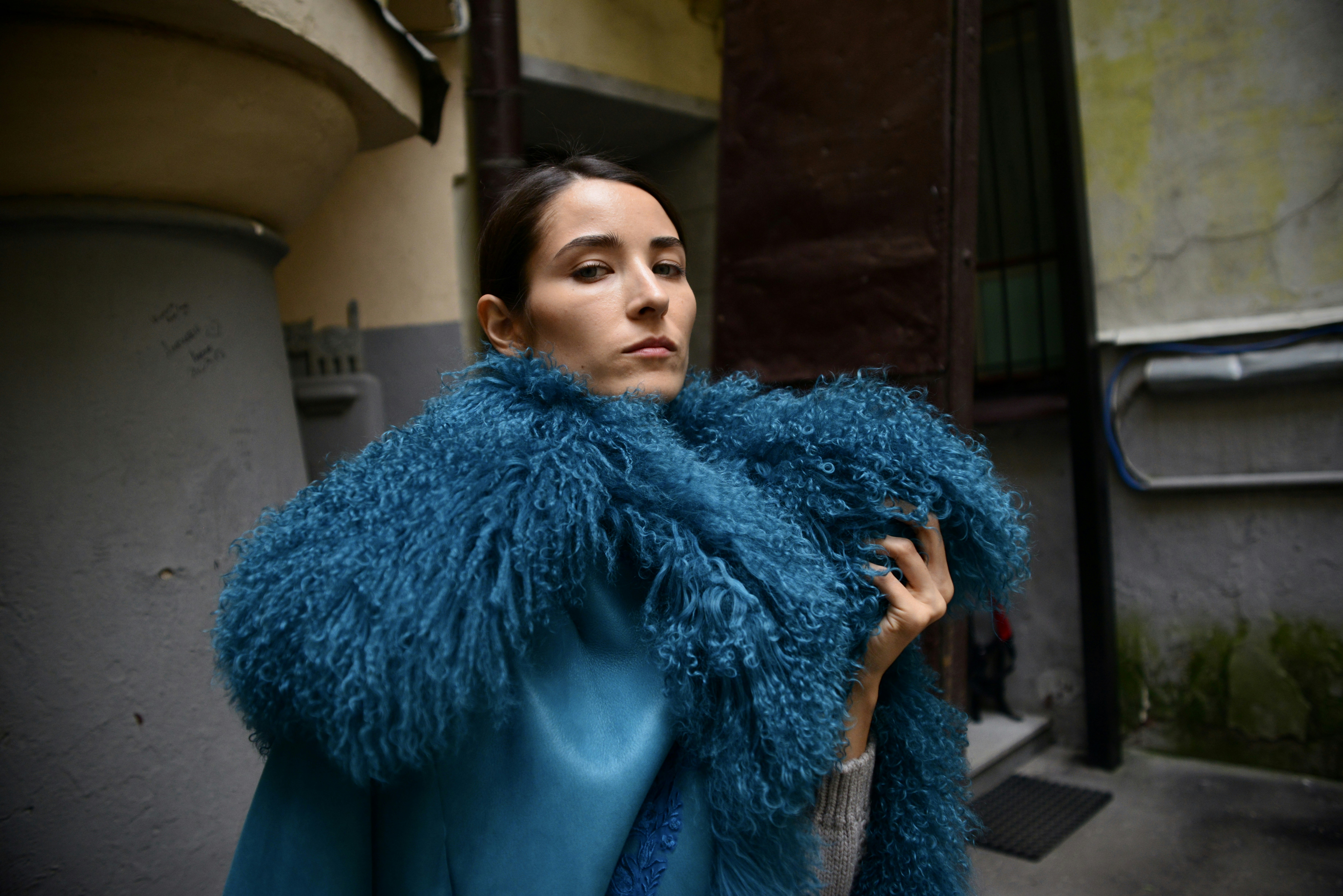 Woman poses in a blue furry coat.
