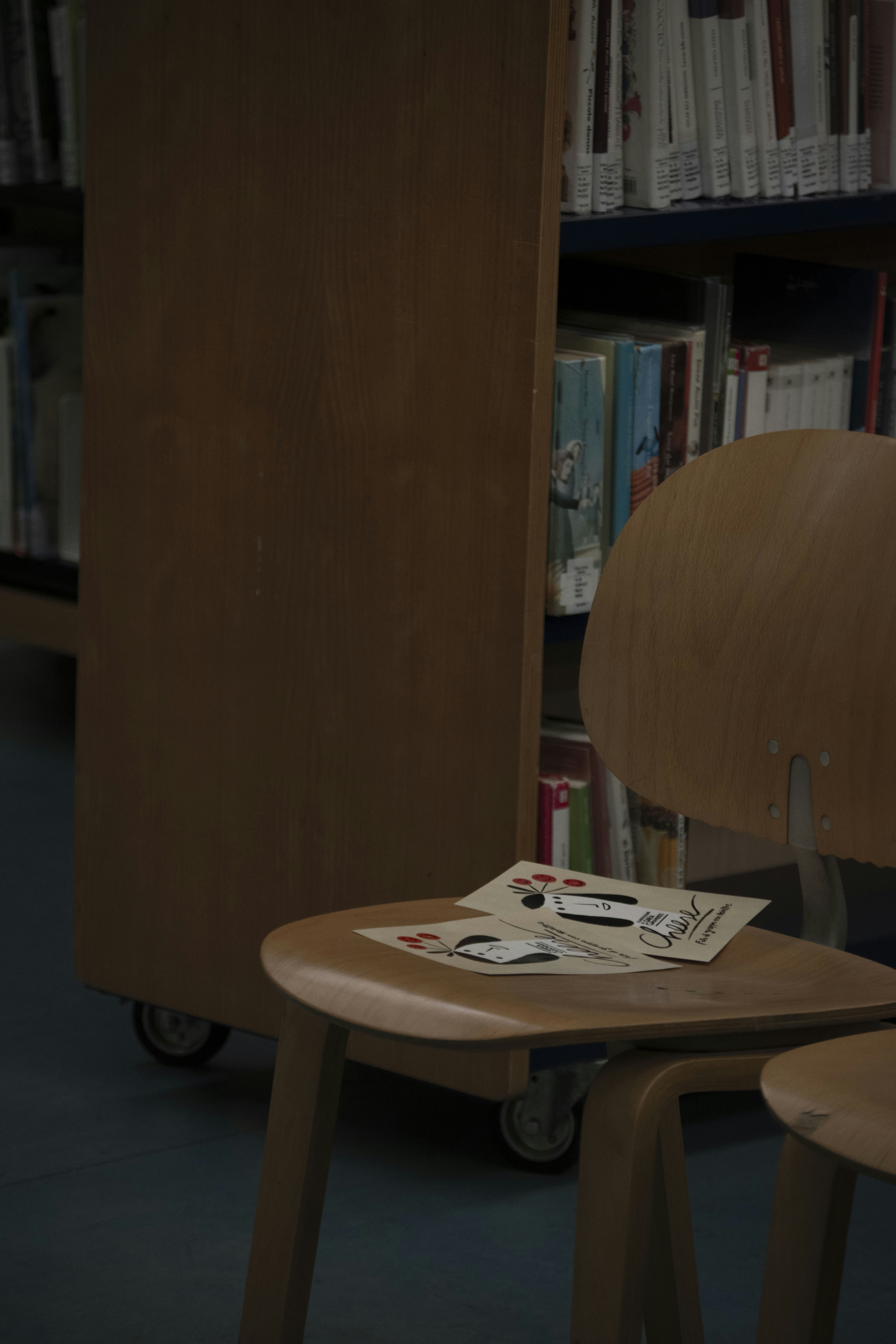 Playing cards are left on a chair in a library.