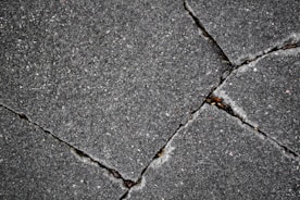 Cracked pavement shows damage and deterioration.