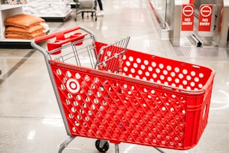 A red target shopping cart sits in a store.