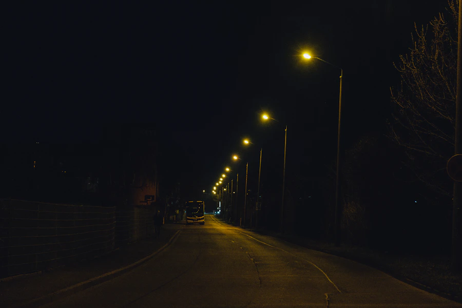 Empty road illuminated by regularly spaced streetlights at night