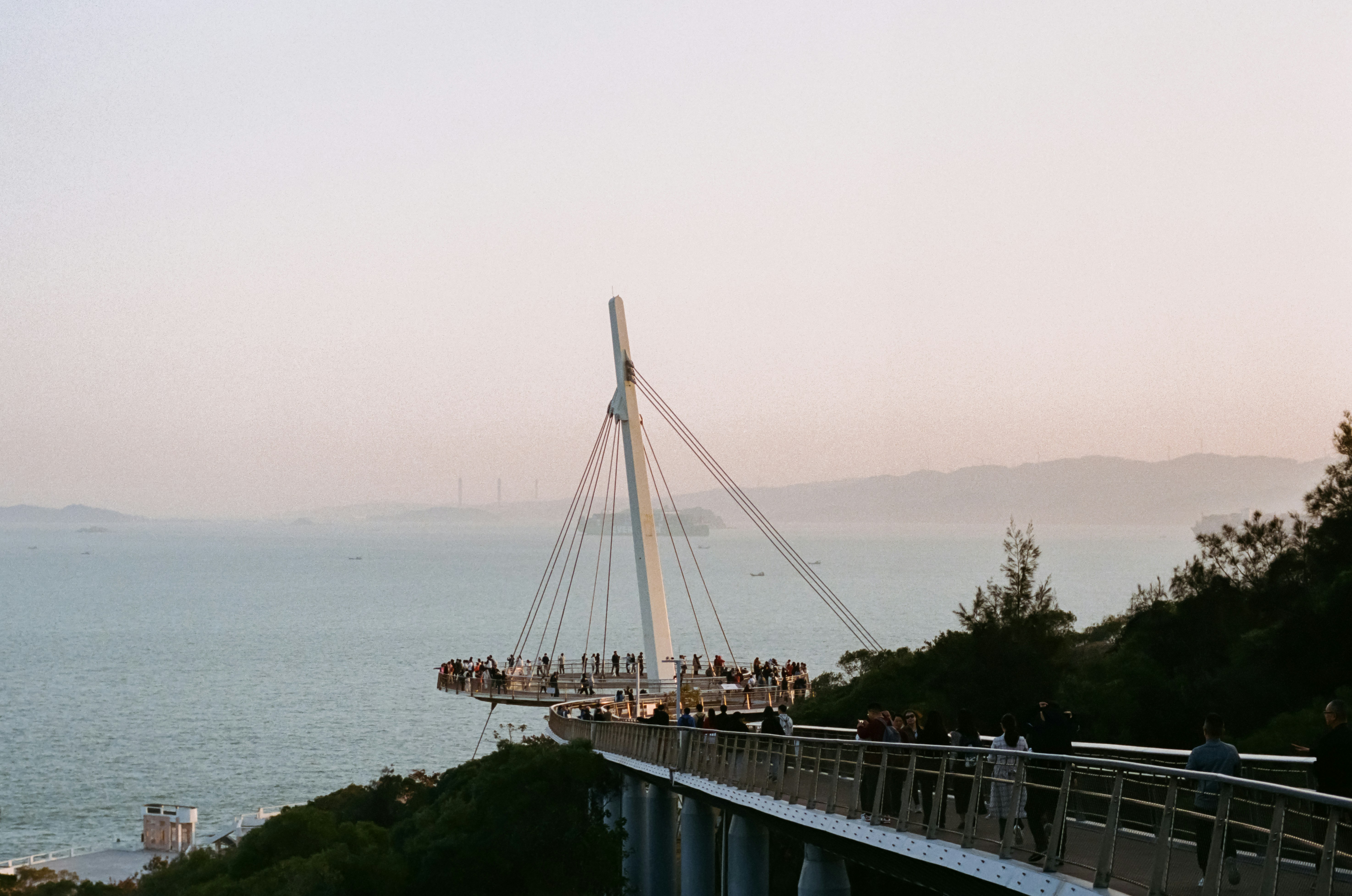 A bridge overlooking the ocean at sunset.