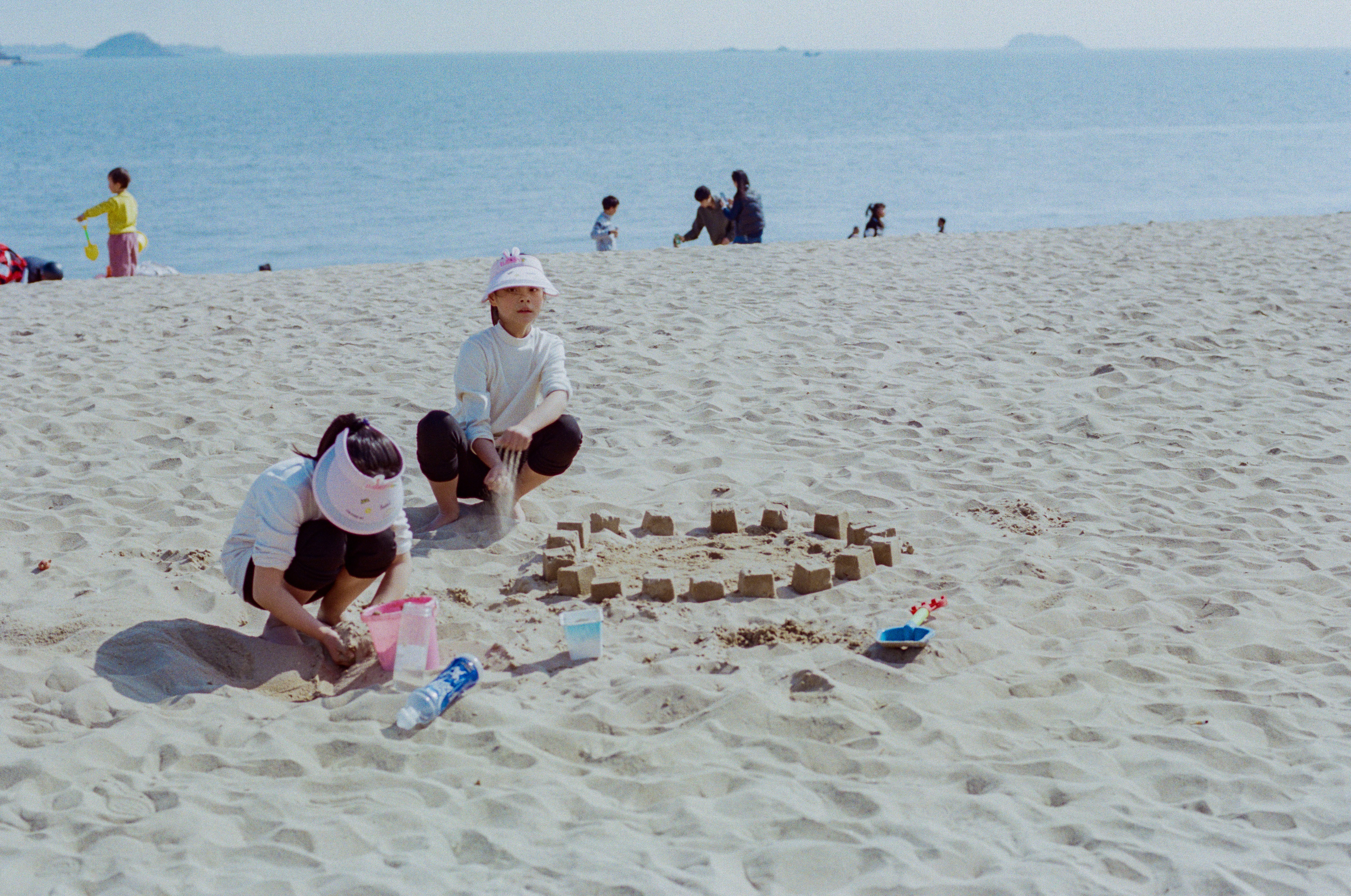 kids building a sandcastle on a white sand beach - best destination for family vacation