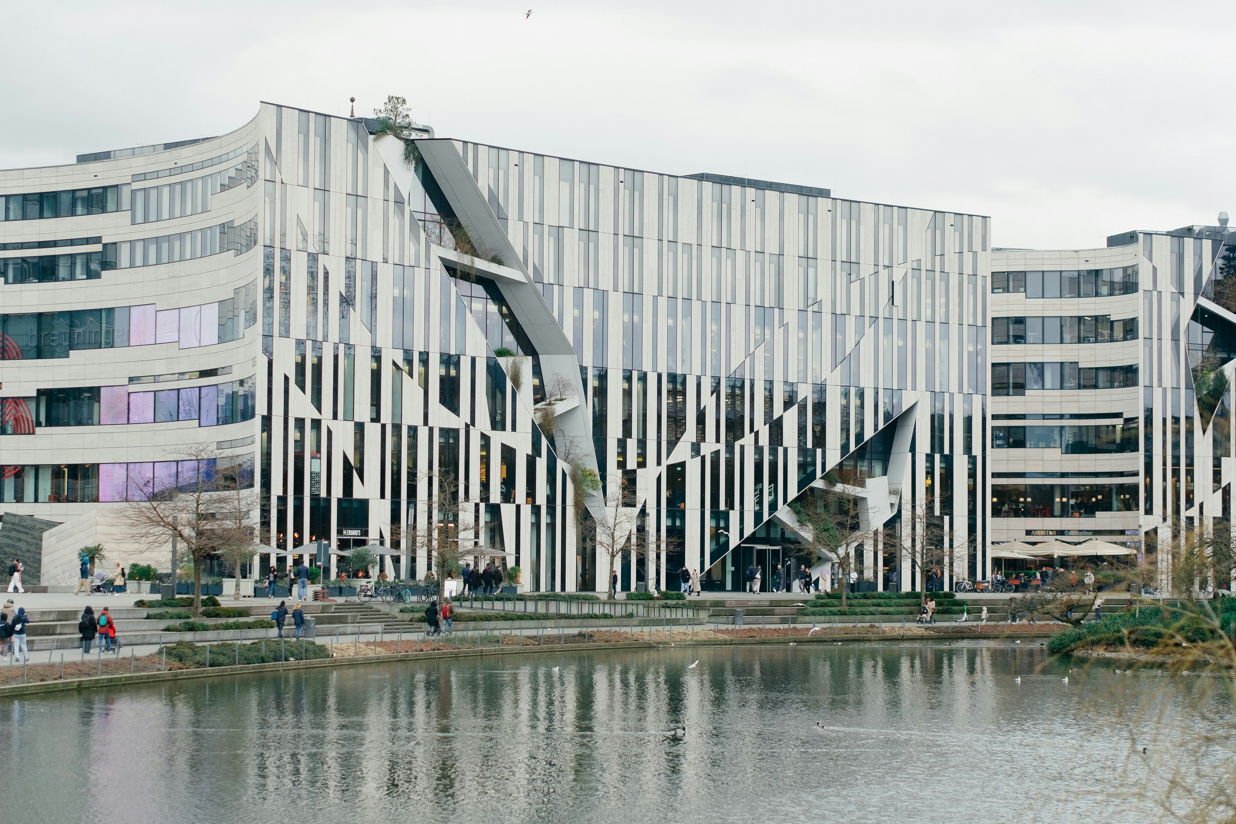 Modern architecture with interesting design by a lake.