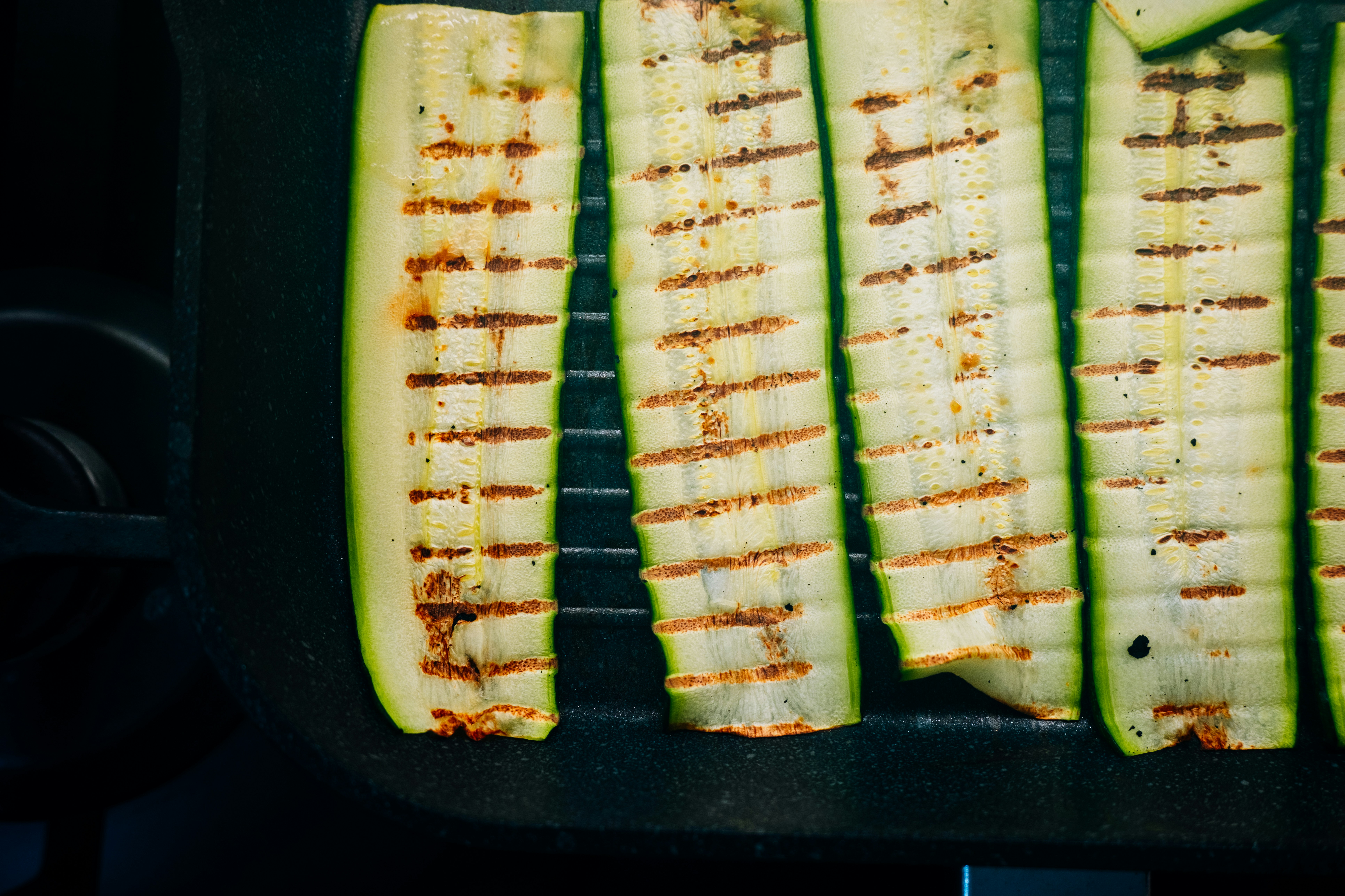 Grilled zucchini slices in a pan.