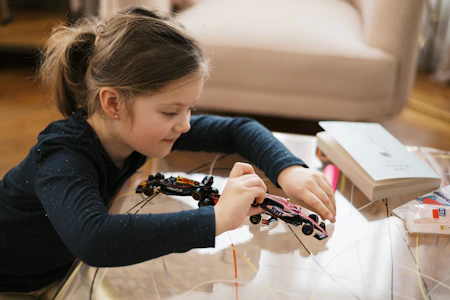 Girl is building a toy car with concentration.