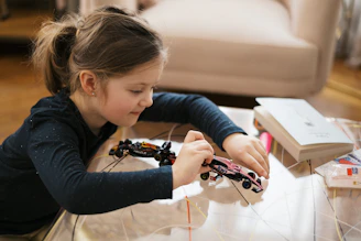 Girl is building a toy car with concentration