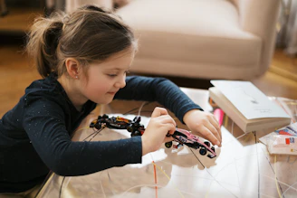 Girl is building a toy car with concentration.