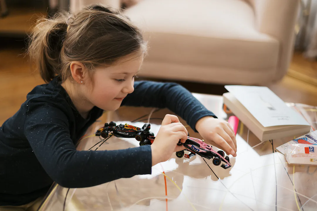 A girl concentrating while building a small model car