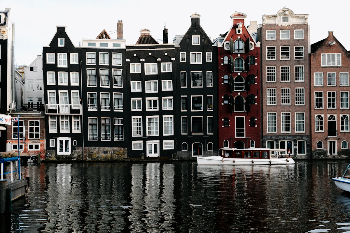 Woningen en bomen langs een Nederlandse waterweg