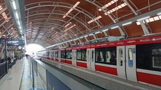 A red train waits at the modern station.