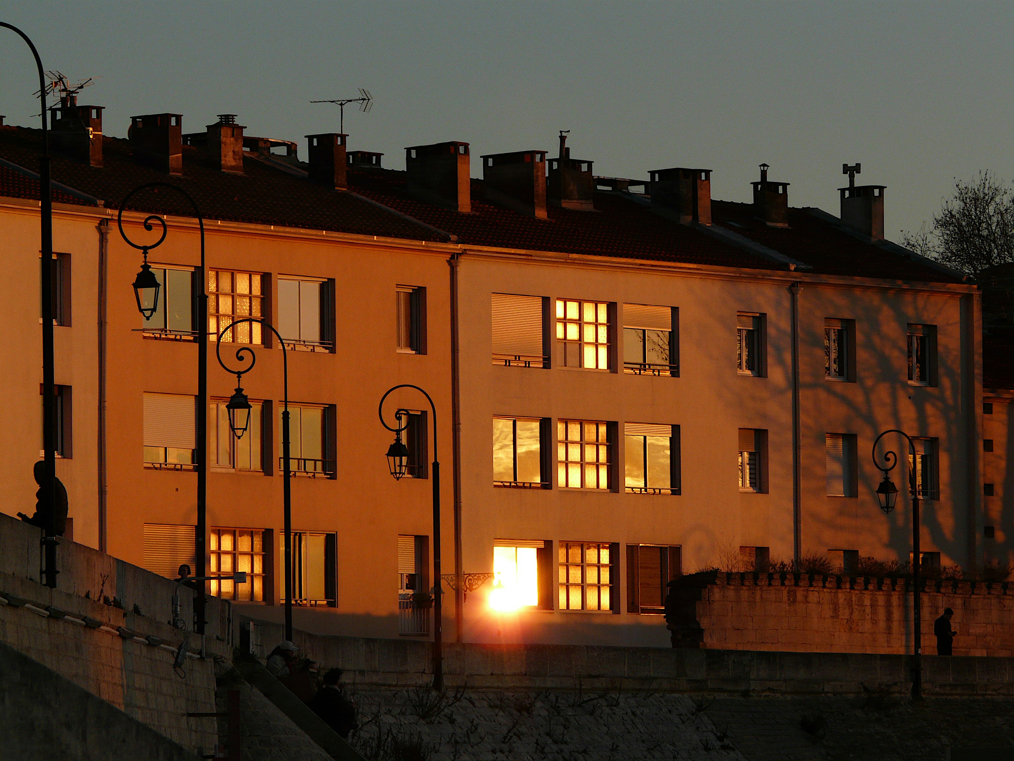 Sunlight bathes buildings in a warm, golden glow.