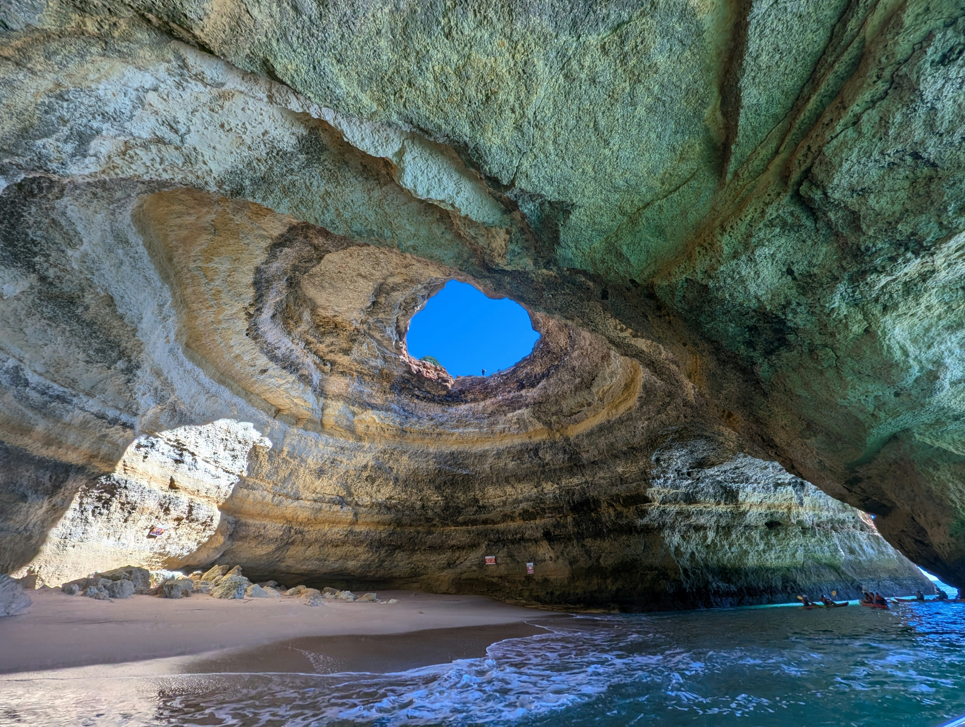A beautiful cave opens to a blue sky.