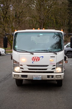 A white aaa tow truck parked outdoors.