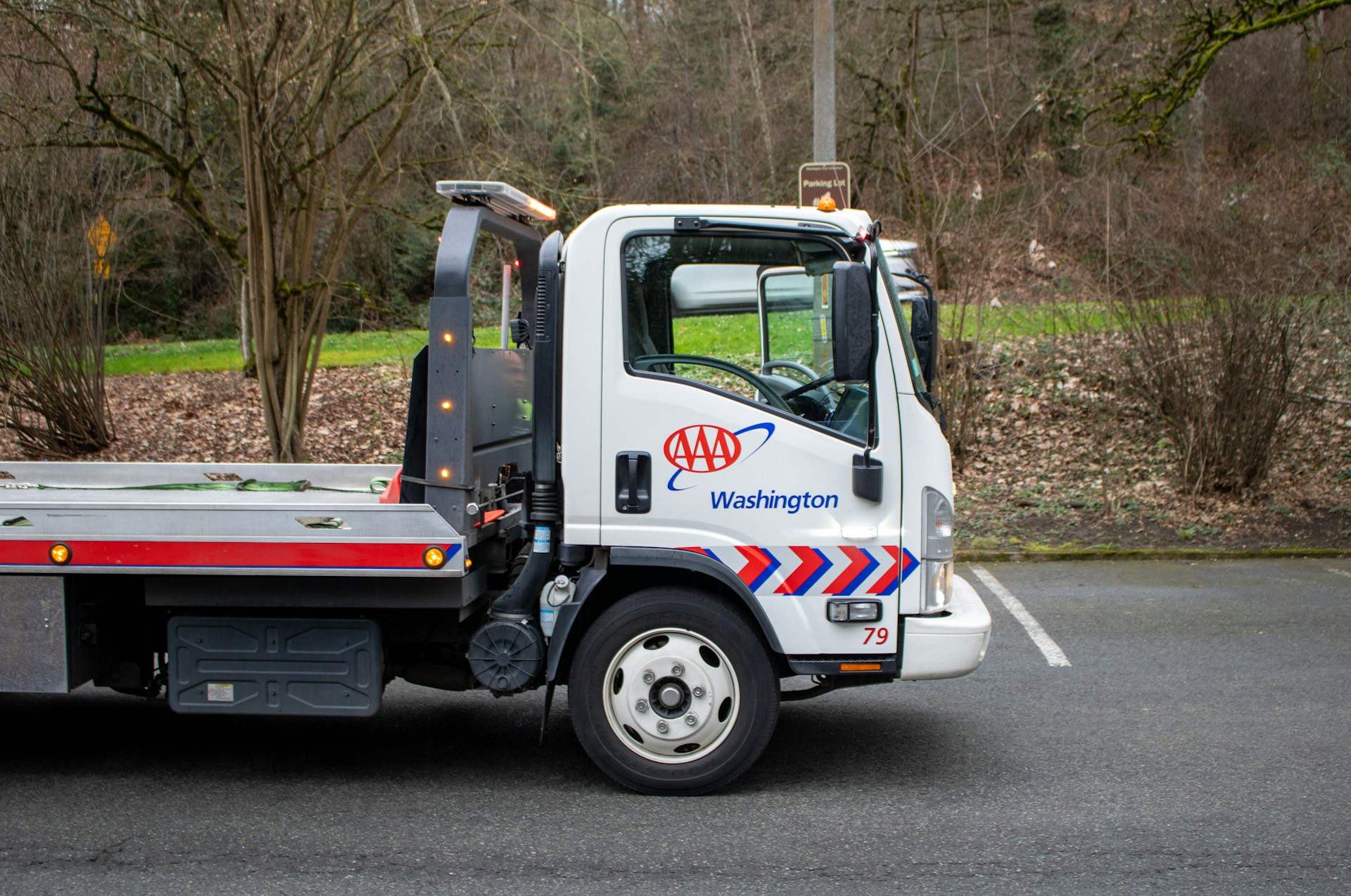 A white tow truck is parked on the street.