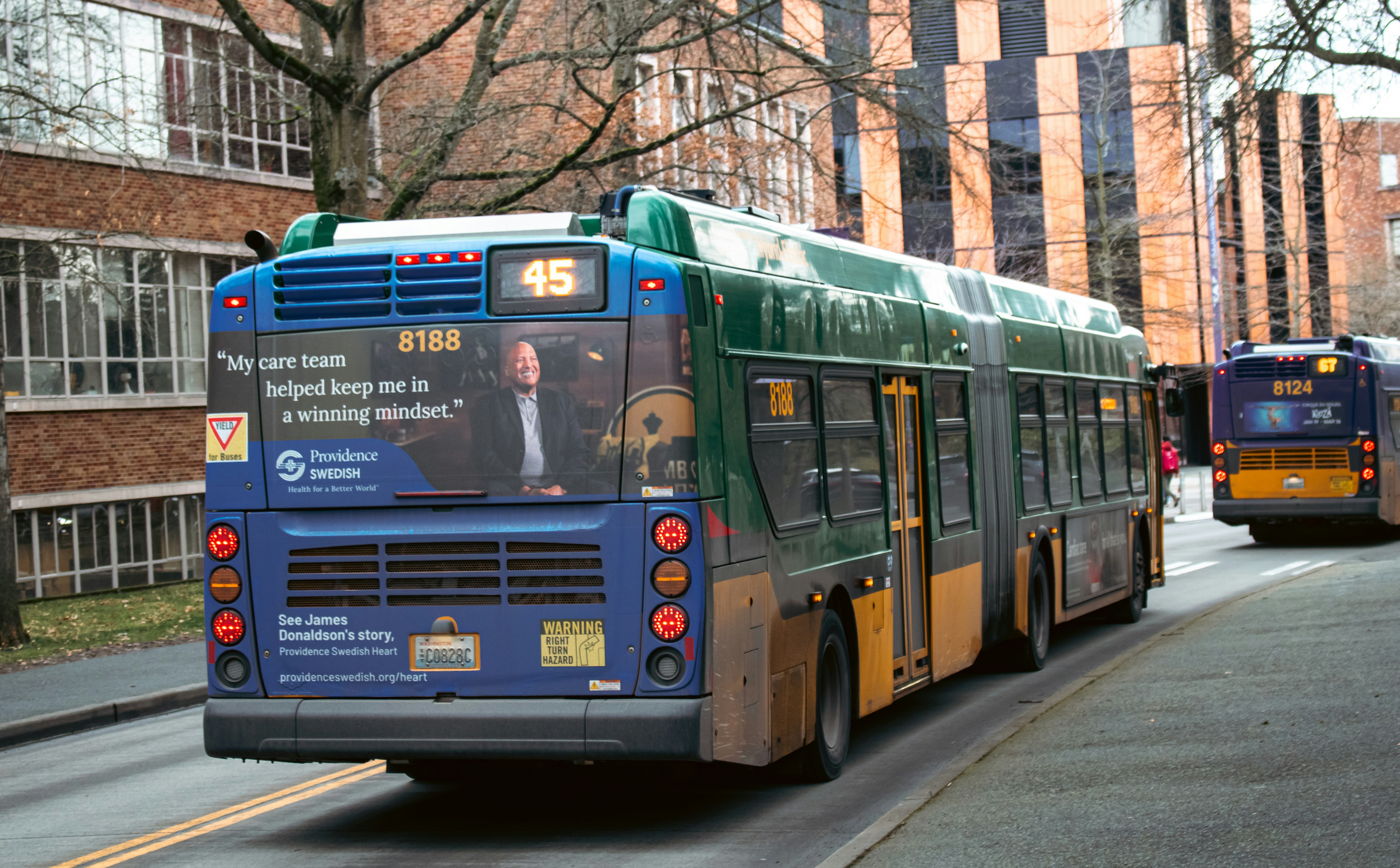 Two buses are driving down a street.