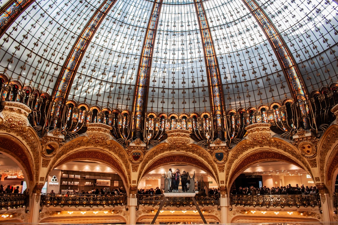 An ornate glass dome crowns a grand building.,