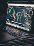 Laptop displays a stock market trading chart