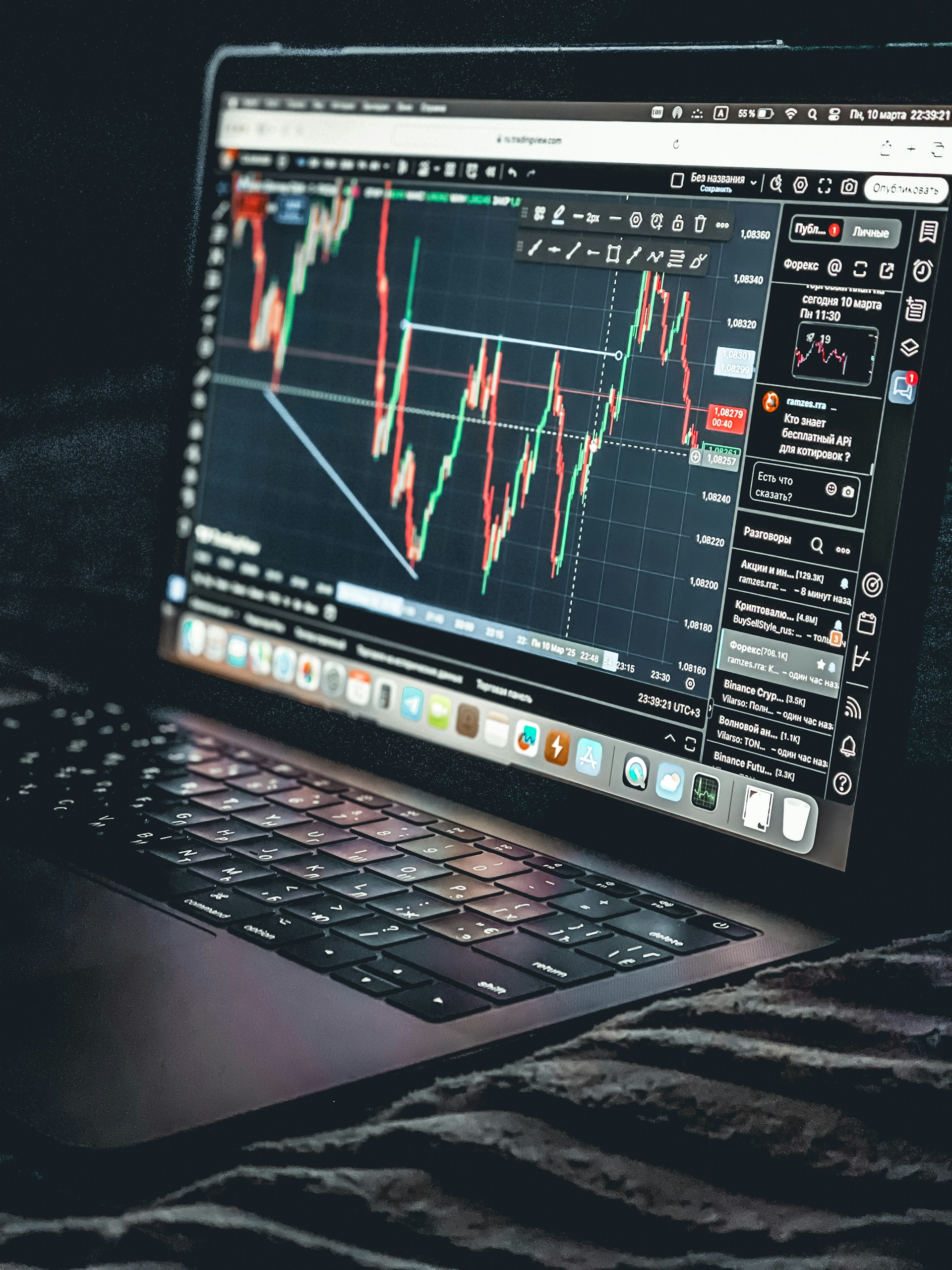 Laptop displays a stock market trading chart.