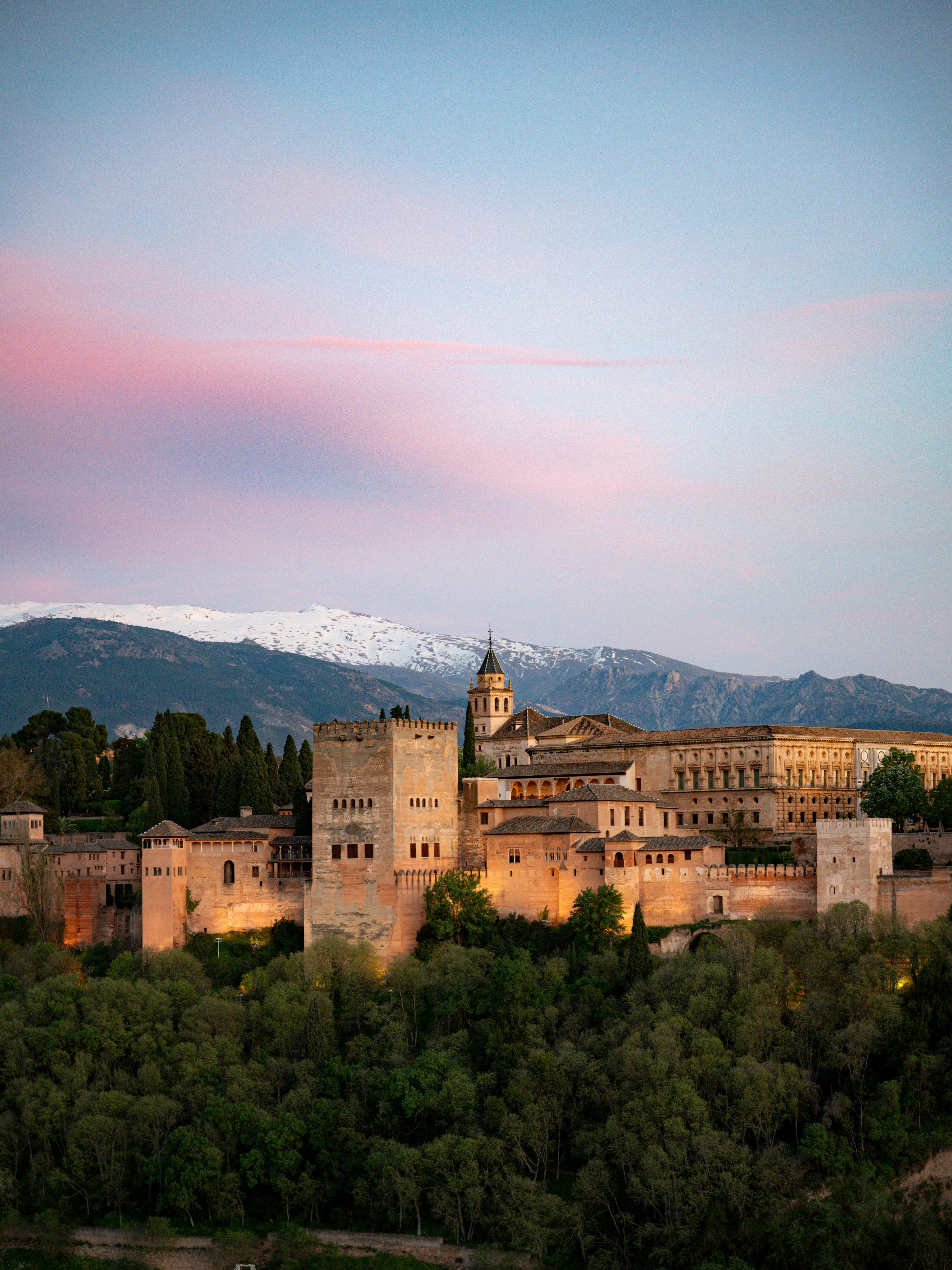 Alhambra palace illuminated under a beautiful sunset sky.