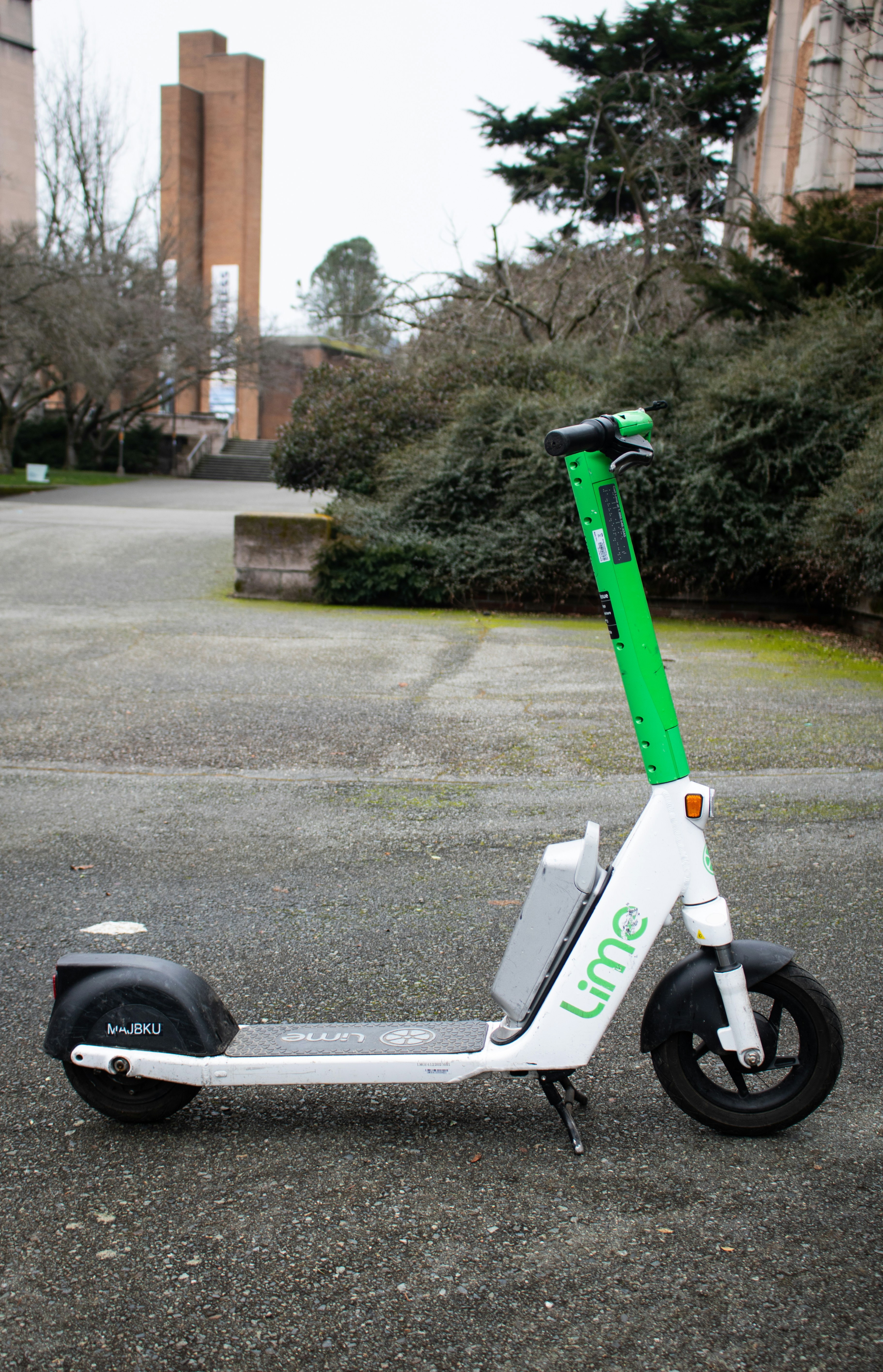 A lime electric scooter is parked on a walkway.