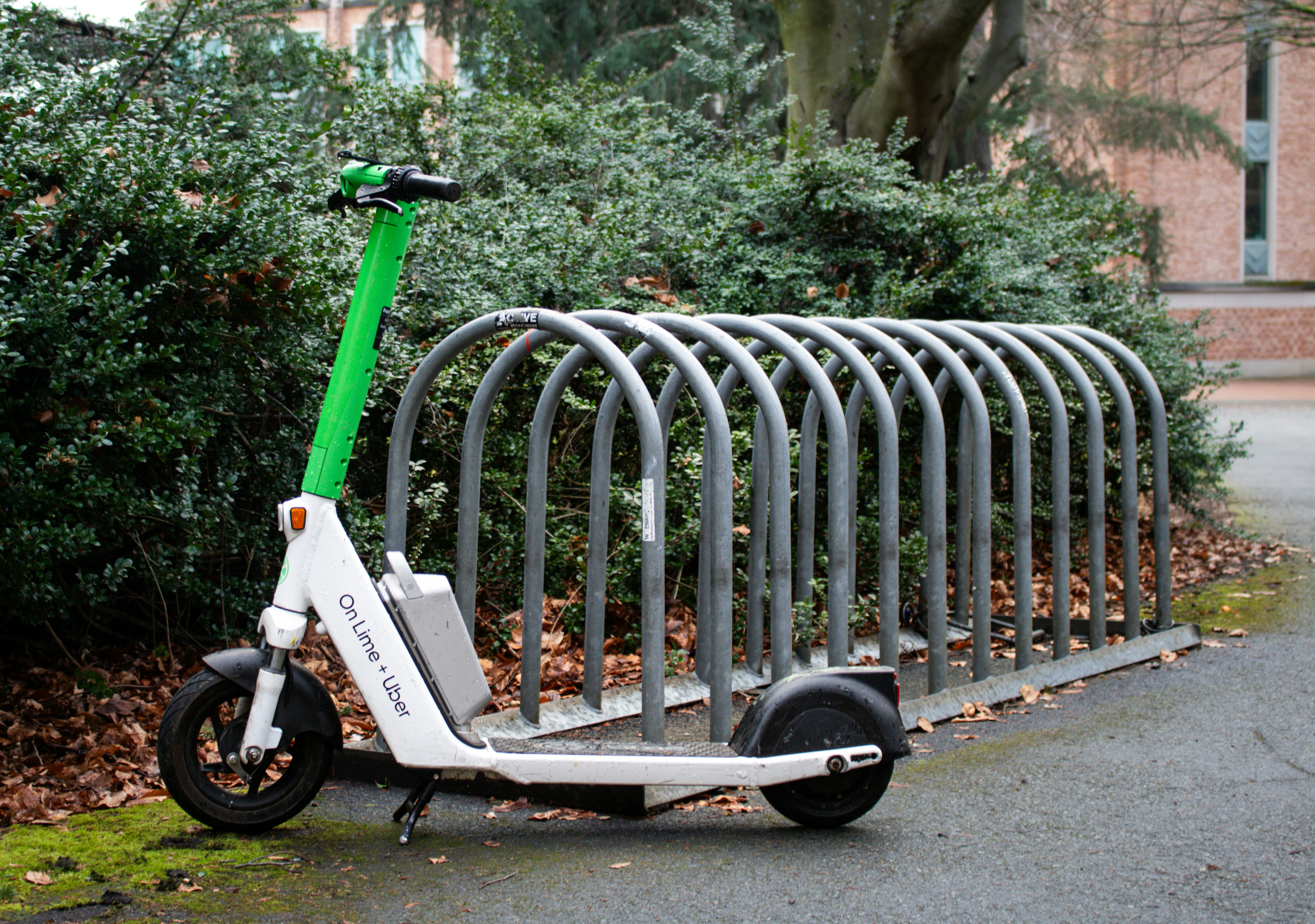 Lime scooter parked next to a bike rack.