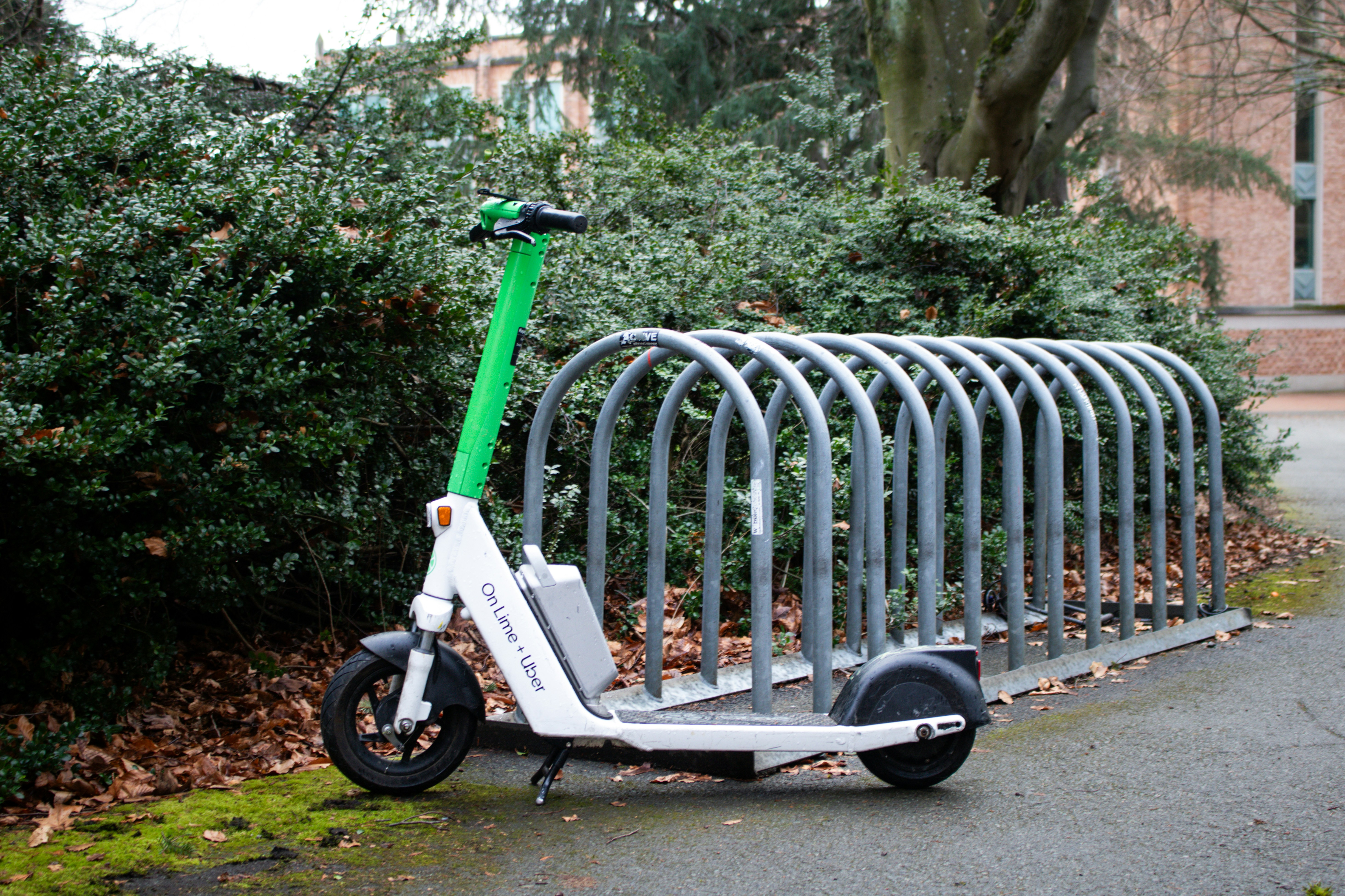 Lime scooter parked in a bike rack.
