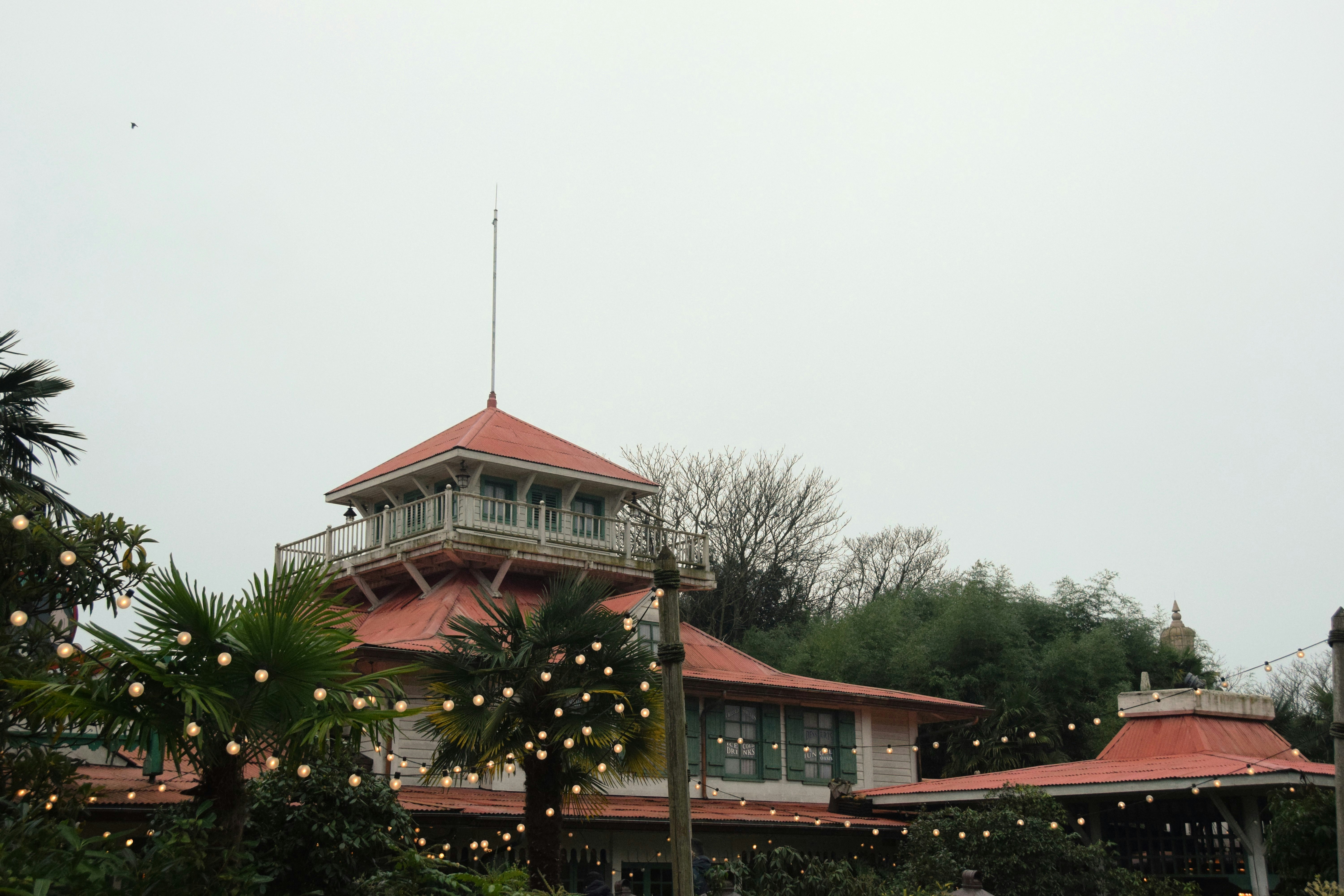 A building with a red roof on a cloudy day.