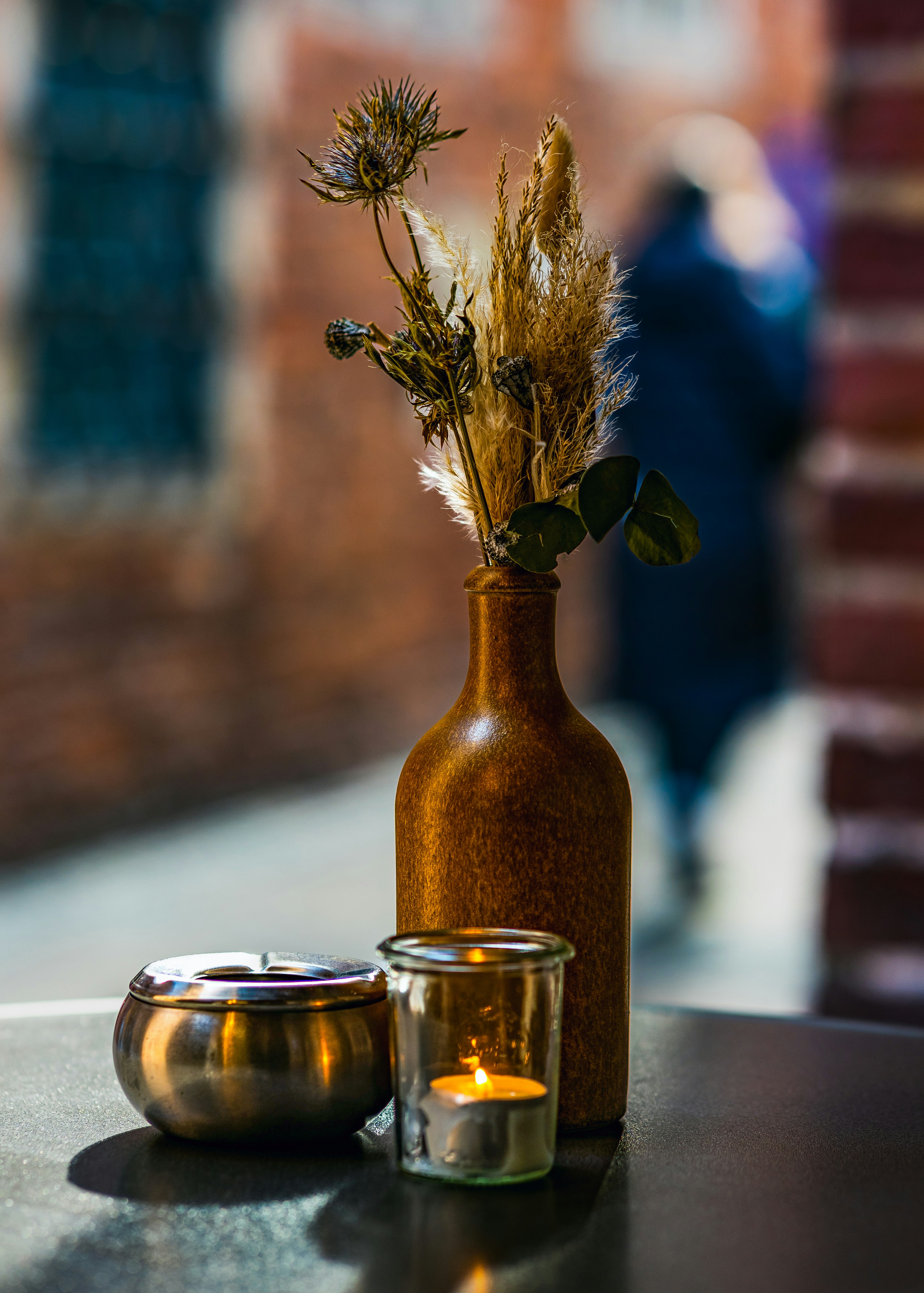 Vase, candle, and ashtray on a table.