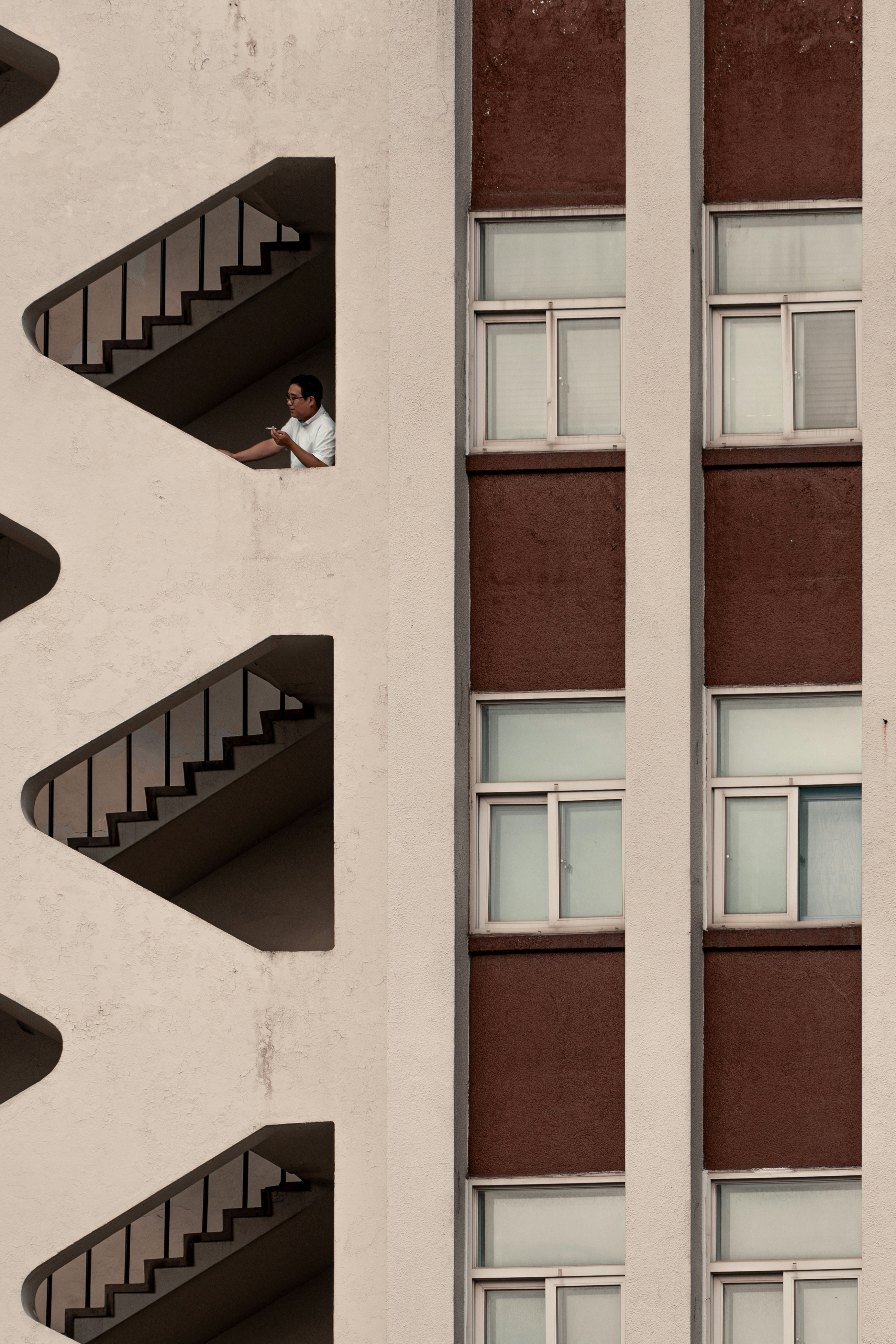Man looks out from a unique architectural building.