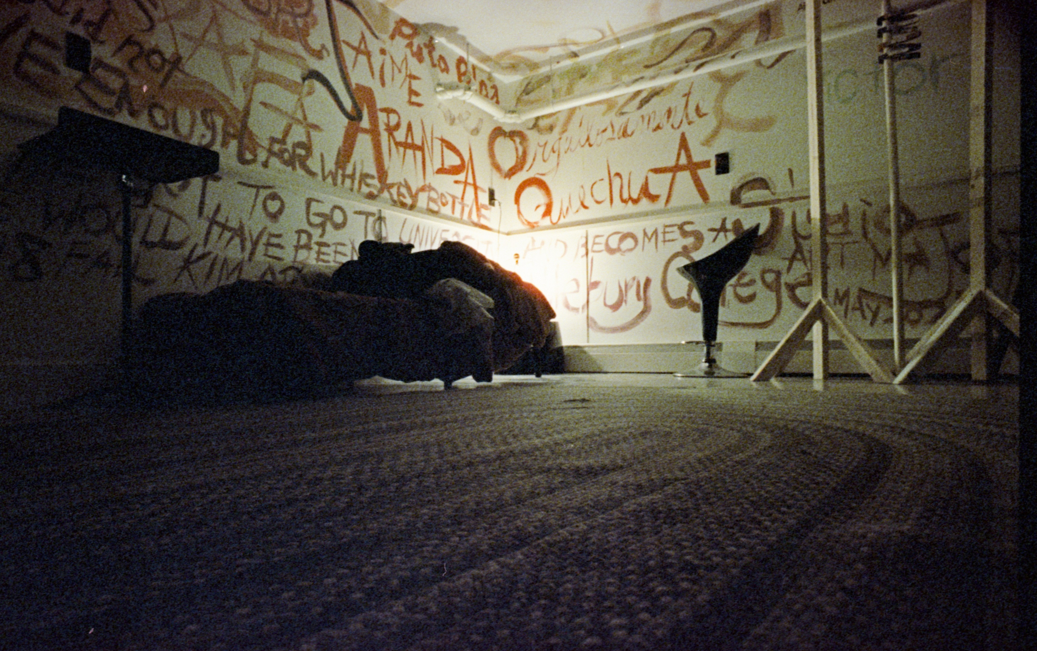 Graffiti-covered room with a couch and ballet barre.