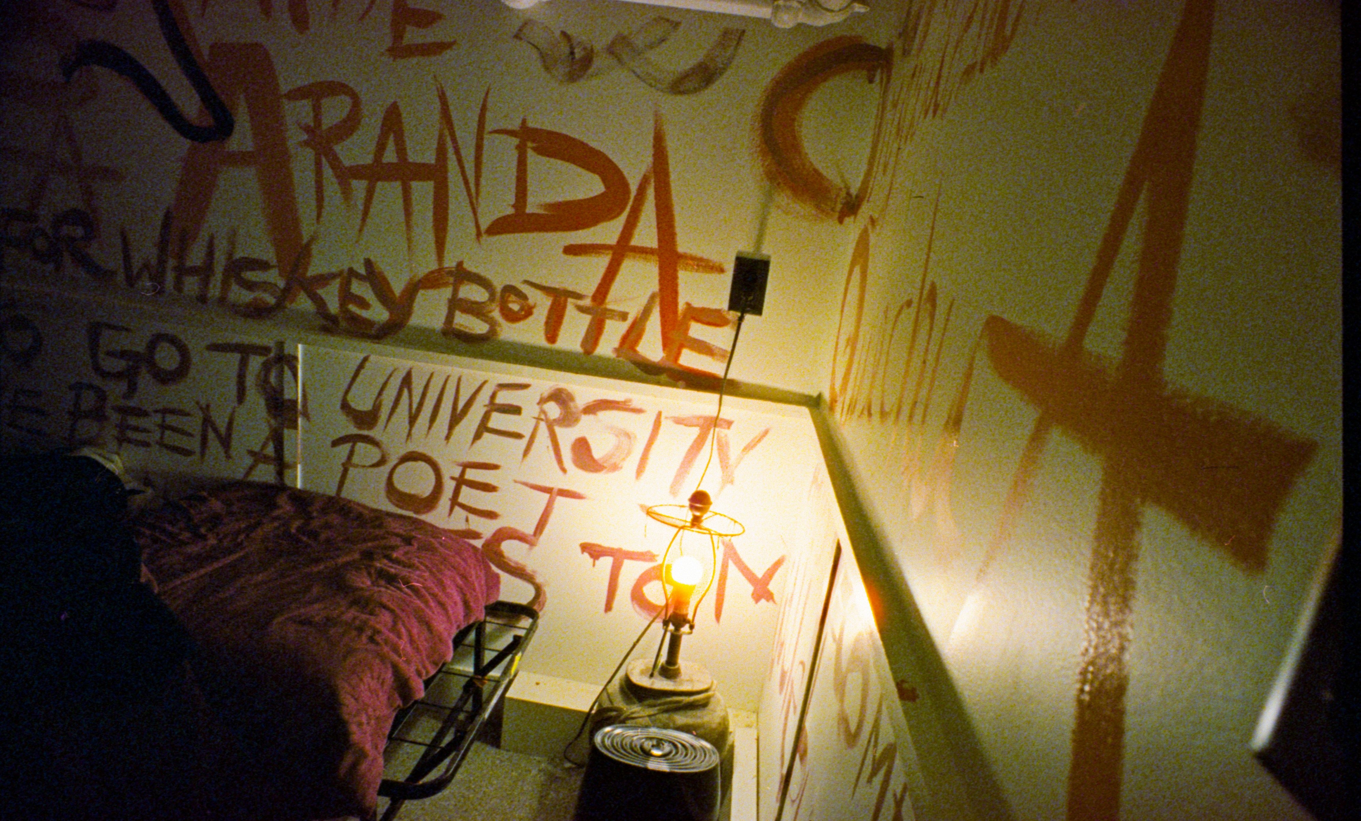 Wall covered in orange graffiti and writing.