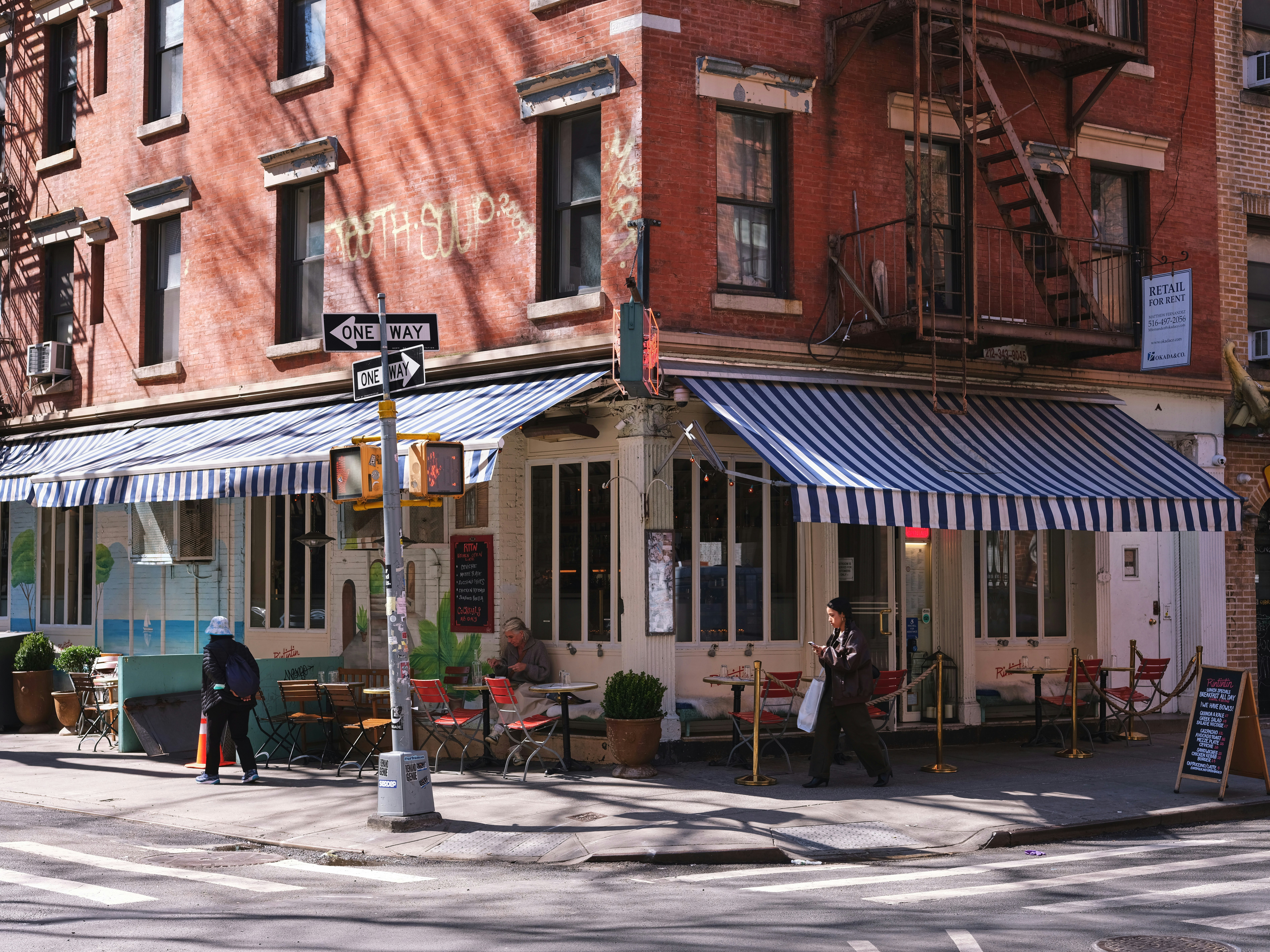 A quaint cafe sits on a busy city corner.