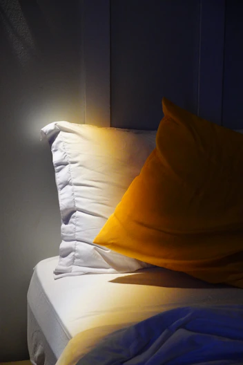 Bed with pillows and sunlight creates a cozy atmosphere.